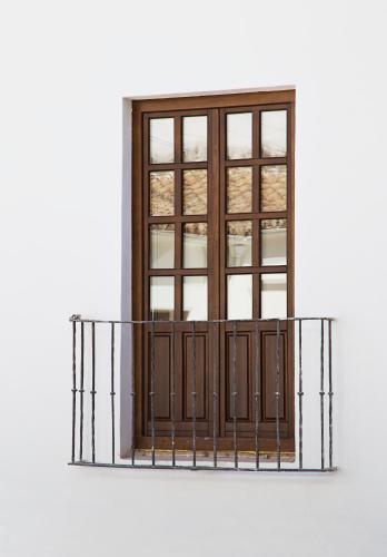 a window on a white building with a metal balcony at One Shot Conde Torrejón in Seville