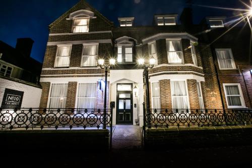 duży ceglany dom z frontowymi drzwiami w nocy w obiekcie Apartments at Number 10 The Abbey w mieście Norwich