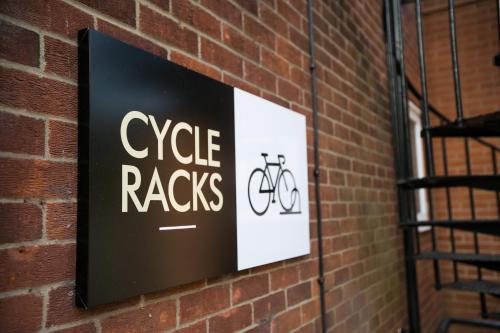 a sign on a brick wall that reads cycle racks at Apartments at Number 10 The Abbey in Norwich
