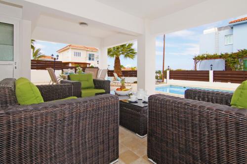 un patio con sedie in vimini e una piscina di Villa Anette a Protaras