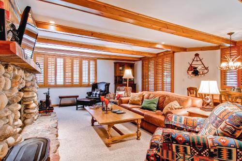 a living room with a couch and a stone fireplace at Kiva Lodge by East West Hospitality in Beaver Creek