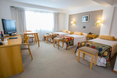 a hotel room with three beds and a television at Hotel Ayres Del Nahuel in San Carlos de Bariloche