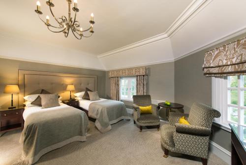 a hotel room with two beds and a chandelier at Piersland House in Troon