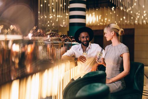 a man and a woman sitting at a bar at Pullman Berlin Schweizerhof in Berlin