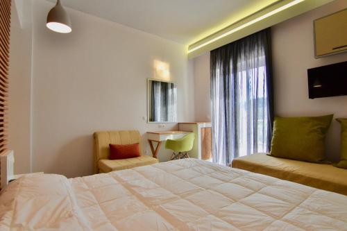 a hotel room with a bed and a chair and a window at Paloma Blanca in Dassia