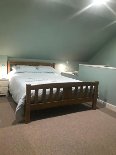 a bedroom with a large bed with a wooden frame at Somersall Park Studio in Chesterfield