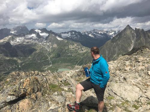 a man sitting on the edge of a mountain at Hotel Hof und Post in Innertkirchen