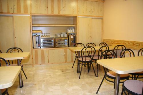 a dining room with tables and chairs and a refrigerator at Ler- Argi in Urnieta