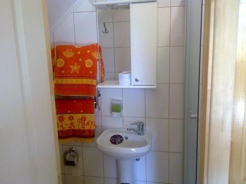 ein Badezimmer mit einem Waschbecken, einem Spiegel und Handtüchern in der Unterkunft Dlya Vseh Motel in Kamjanez-Podilskyj