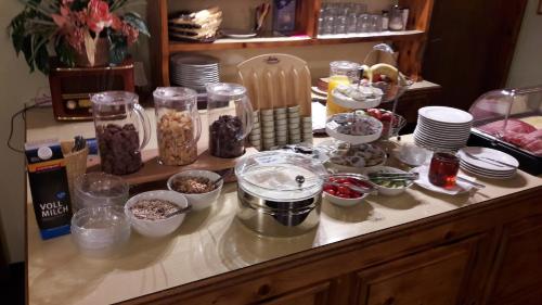 a counter with bowls of food and jars of food at Alpengasthof Draxler in Forstau