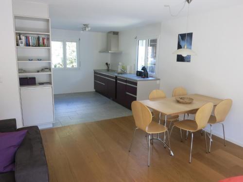 uma cozinha e sala de jantar com mesa e cadeiras em Apartment Beeli em Splügen