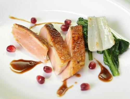 a white plate of food with meat and vegetables at Hotel Ristorante Al Sorriso in Soriso