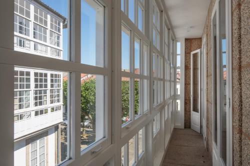 a hallway with large windows and a hallway with a hallway at Hotel Atalaia B&B in Santiago de Compostela