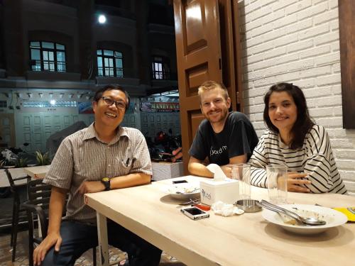 a group of three people sitting at a table at Arya Inn in Pematangsiantar