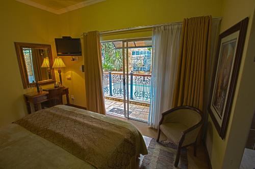 a bedroom with a bed and a sliding glass door at Le Cozmo Guesthouse in Johannesburg