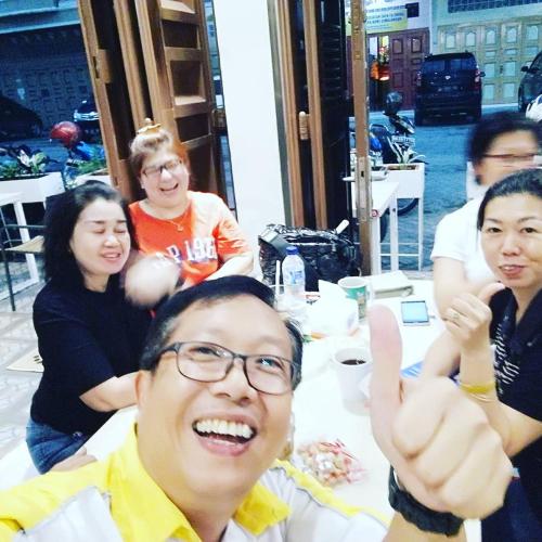a group of people sitting at a table giving a thumbs up at Arya Inn in Pematangsiantar