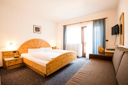 ナツ・シャーヴェスにあるHotel Föhrenhofのベッドルーム(大型ベッド1台、ソファ付)