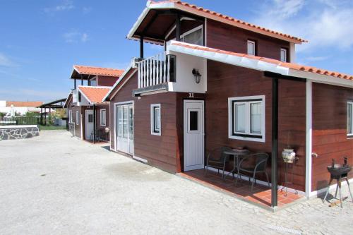 een klein houten huisje met een tafel op een oprit bij Lusitaurus in Montoito