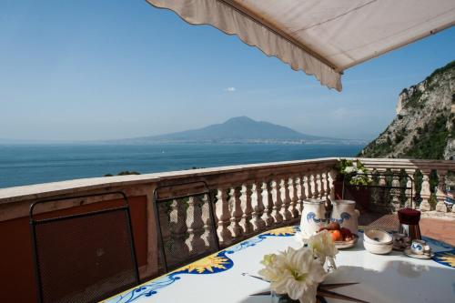 stół na balkonie z widokiem na ocean w obiekcie Villa Margi w mieście Vico Equense