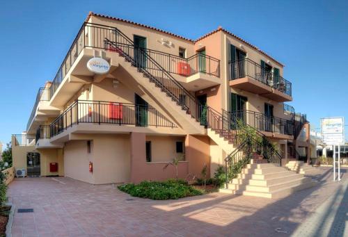 a building with stairs on the side of it at Margarita Beach Hotel in Agia Marina Nea Kydonias