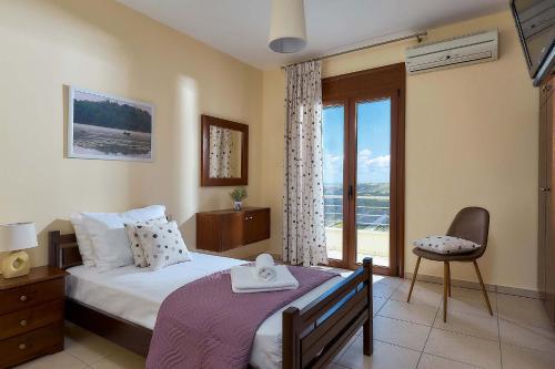 um quarto com uma cama e uma grande janela em Villa Ginger em Voútai