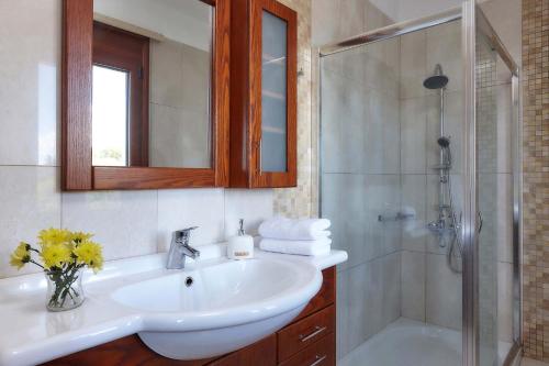 biała łazienka z umywalką i prysznicem w obiekcie Villa Ginger w mieście Voútai