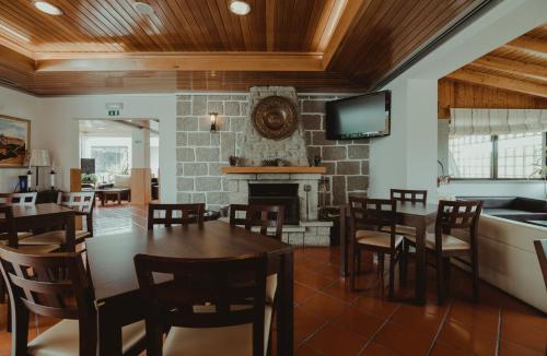 a dining room with a table and a fireplace at Hotel Albergaria Senhora do Espinheiro in Seia