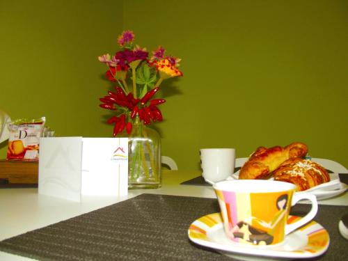 una mesa con una taza de café y un plato de cruasanes en Cimarhosa House, en Rho