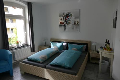 Un dormitorio con una cama con almohadas azules y una ventana en Hotel La Principessa, en Hameln
