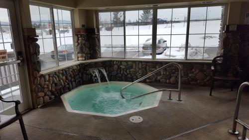 a jacuzzi tub in a room with windows at Microtel Inn & Suites by Wyndham Bozeman in Bozeman