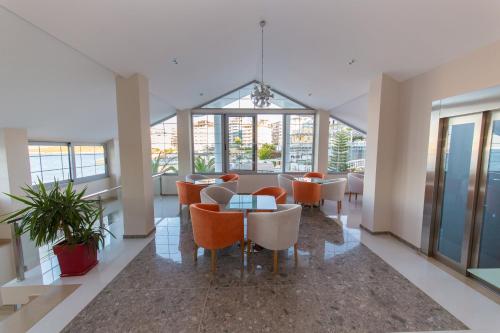 a dining room with tables and chairs and windows at Hotel Saranda Palace in Sarandë
