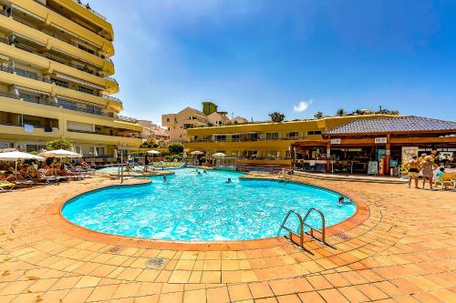 a large swimming pool in front of a building at Santa Maria 2 bedrooms in Adeje