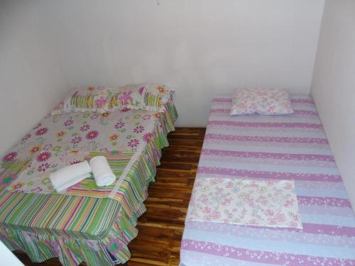 two twin beds in a room with wooden floors at Hostal Villas Mexico in San Juan del Sur