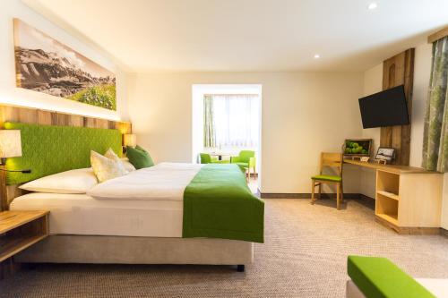 a hotel room with a bed and a television at Alpenhotel Wurzer in Filzmoos