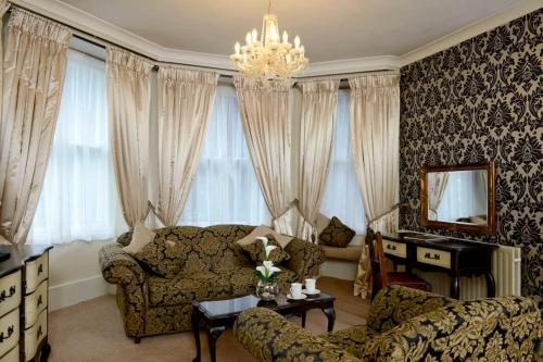 sala de estar con sofá y lámpara de araña en Stags Head Hotel, en Bowness-on-Windermere