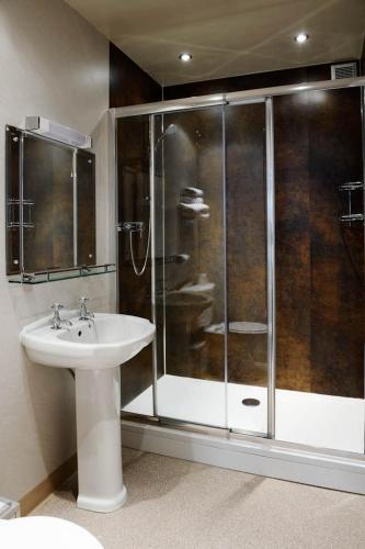a bathroom with a glass shower and a sink at Stags Head Hotel in Bowness-on-Windermere