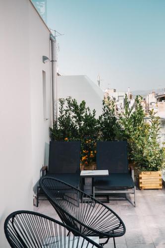 a couple of chairs and a table on a balcony at 360Degrees Pop Art Hotel in Athens