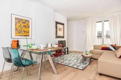 マドリードにあるBNBHolder Luxury Apartment III PLAZA DE ESPAÑAのリビングルーム(テーブル、ソファ付)