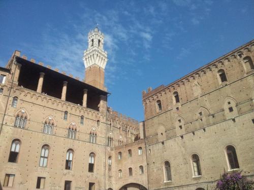 a building with a clock tower on top of it at Al Mercato B&B in Siena