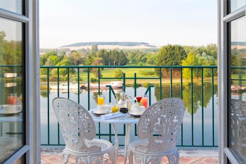 a table and chairs on a balcony with a view at La Côte Saint Jacques in Joigny