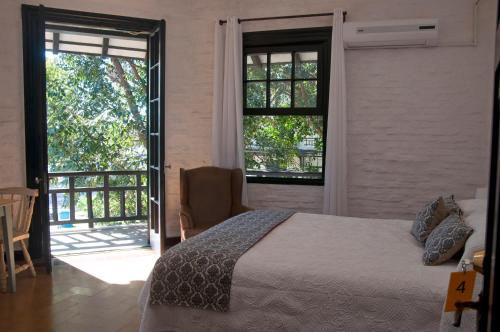 a bedroom with a bed and a sliding glass door at Santoral Restaurante y Posada Pet Friendly in Atlántida