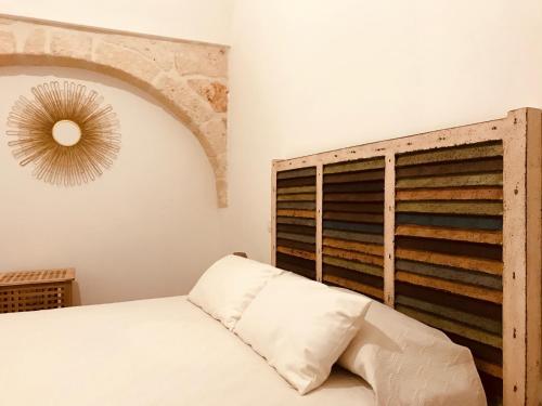 a bedroom with a bed and a wooden headboard at Zì Marì - Via Sirene in Polignano a Mare