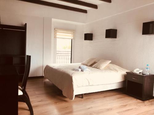 a bedroom with a large bed and a window at Hotel Bellavista Quito in Quito