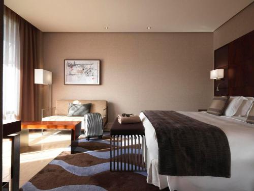 a hotel room with a bed and a chair at Hotel Miramar Barcelona GL in Barcelona