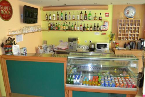 a store with a counter with soda bottles on the wall at Arenilha Guest House in Vila Real de Santo António