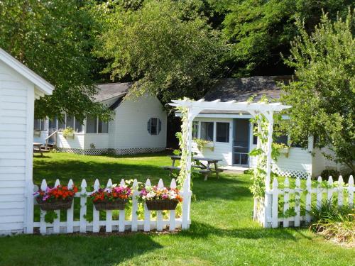 a garden with a fence and a house at Bar Harbor Cottages & Suites in Bar Harbor
