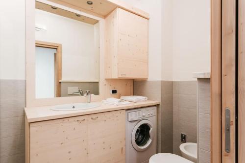 a bathroom with a washing machine and a sink at Appartamento Stelvio in Valdisotto