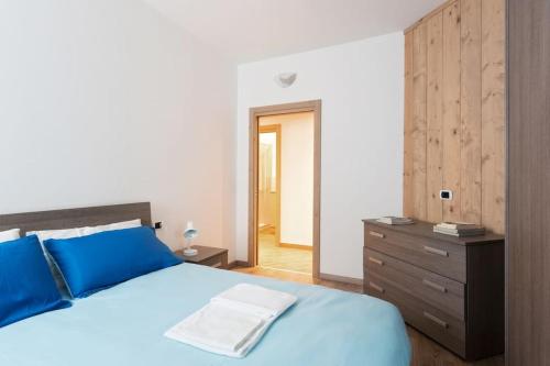 a bedroom with a blue bed and a wooden dresser at Appartamento Stelvio in Valdisotto