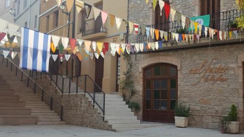 a building with prayer flags hanging from a balcony at Cal Fuster De La Plaça in San Martín de Tous