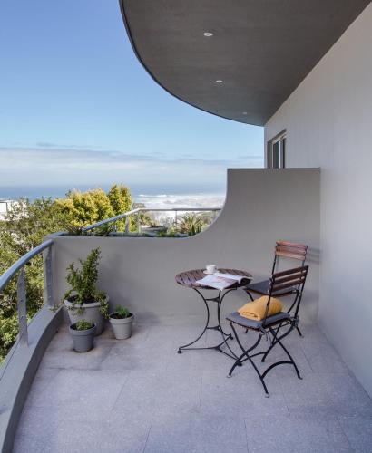 a patio with a table and chairs on a balcony at Sovn Boutique Hotel in Cape Town